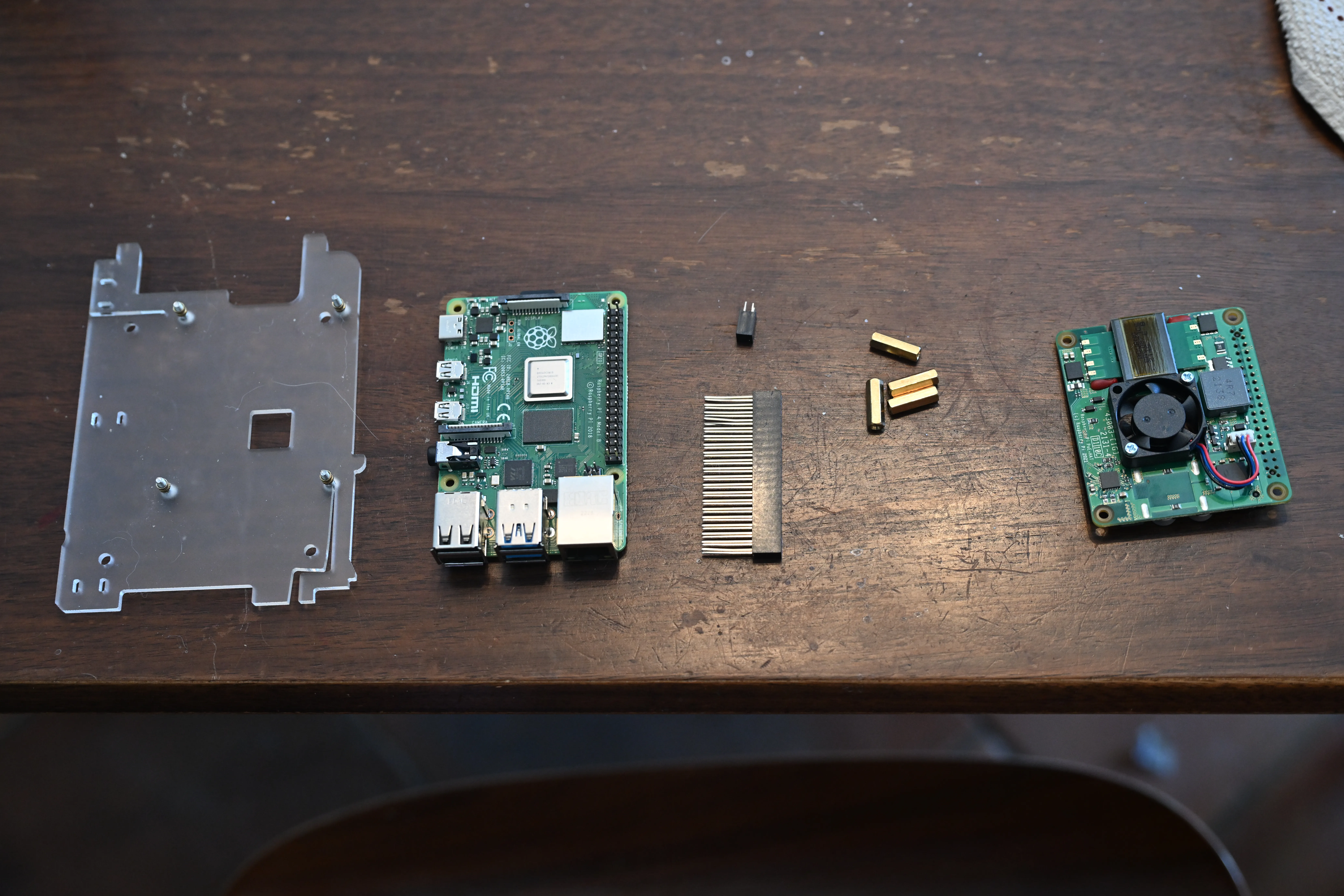 Plastic rack from cluster case with screws and spacers installed, Raspberry Pi 4, extra tall headers for 4-pin and 40-pin array, brass standoffs, and a PoE+ hat