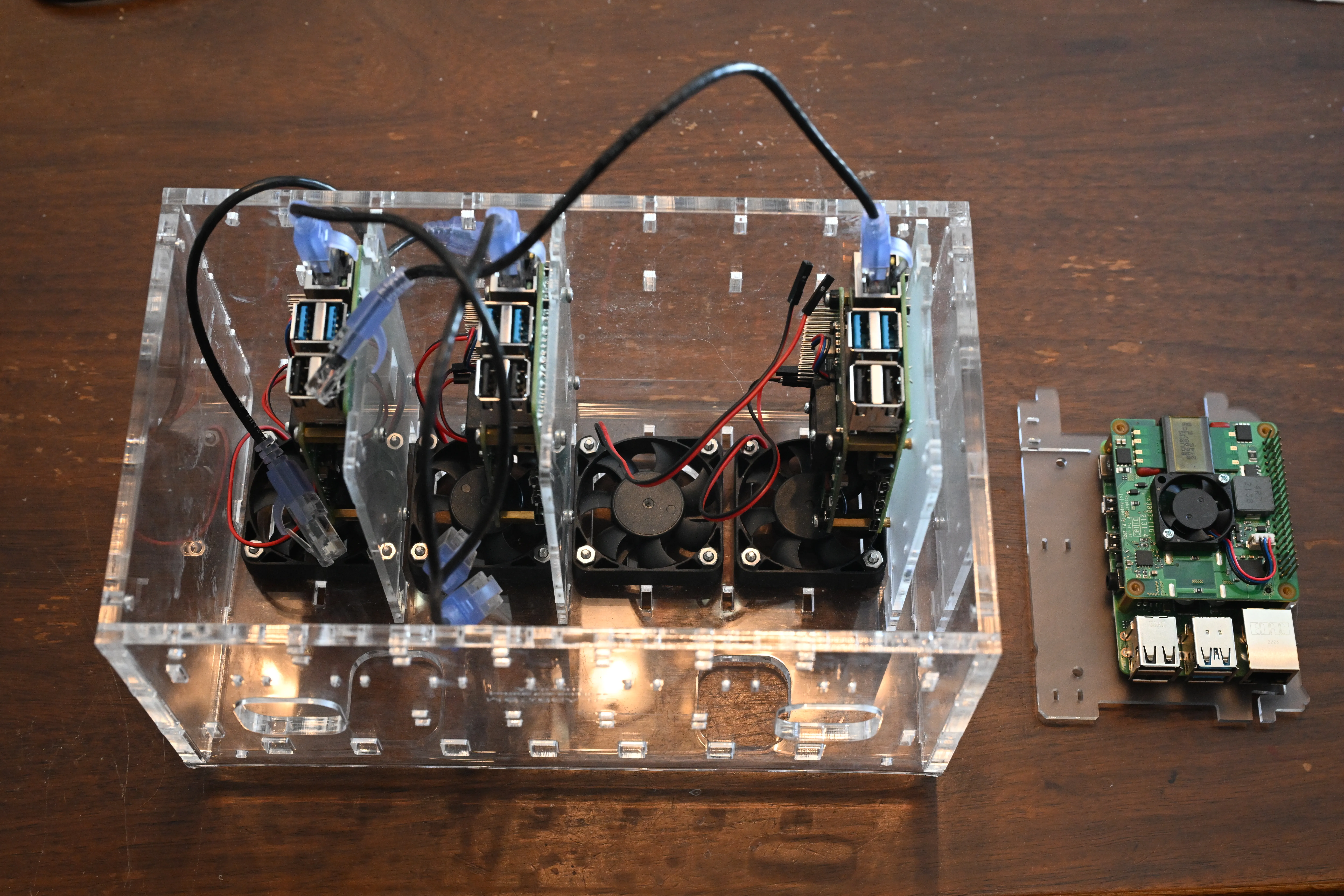 C4Labs Cloudlet CASE with 3 Raspberry Pis installed and plugged into fans, with one Raspberry Pi on its plastic rack ready to be plugged into the fan and installed in the last open place in the CASE
